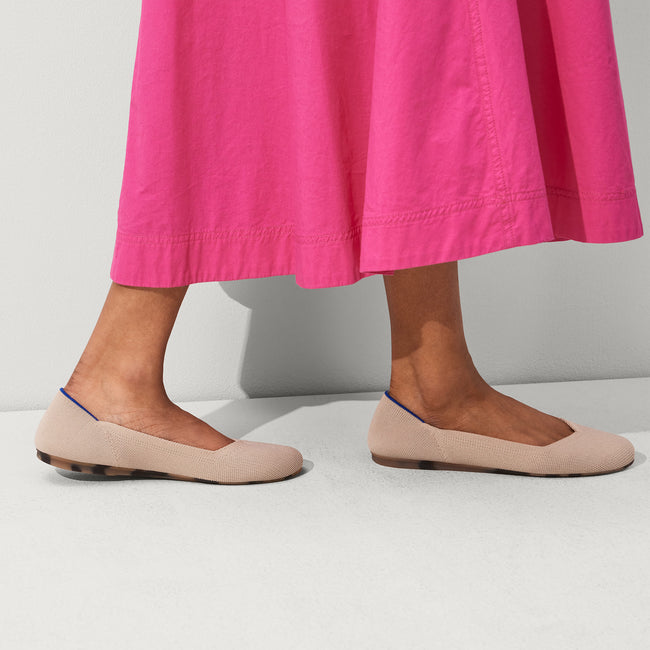 The Flat round toe shoe in Ecru shown on-model at an angle.