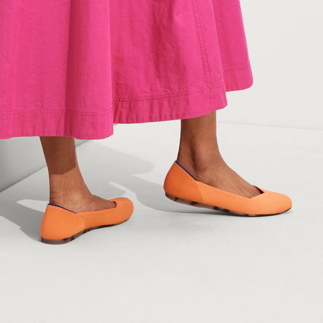 hover | Model wearing The Flat in Tangerine.