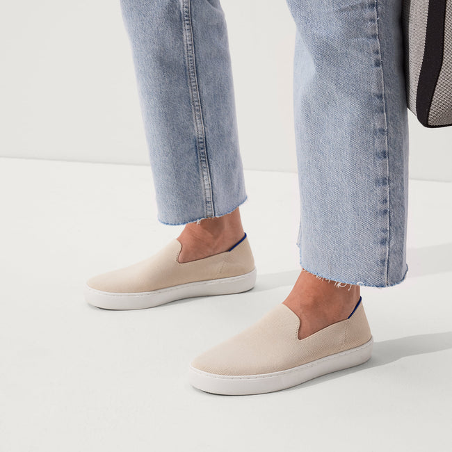 The slip-on Sneaker in Sand shown on-model at an angle.