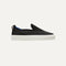 The Kids slip-on Sneaker in Black shown from a side view showing the outsole.