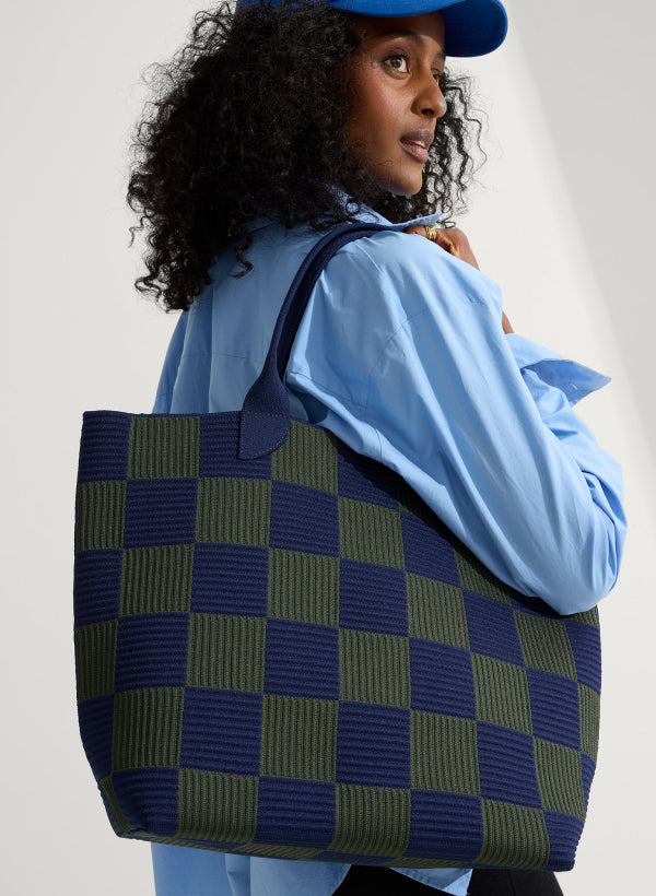 A model carrying The Lightweight Tote in Checker Blue.