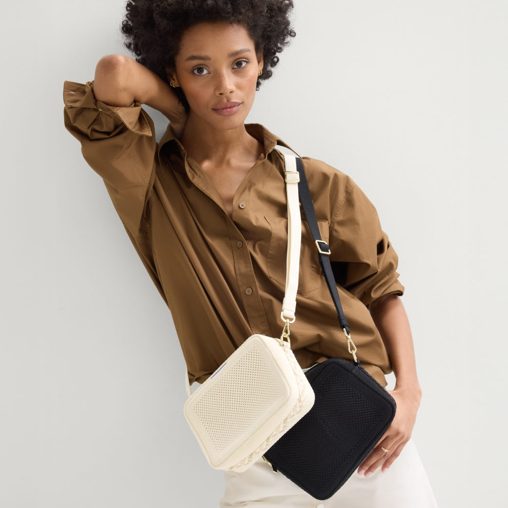 The Crossbody Camera Bag in  Cream Twist Open-Knit worn as a crossbody by a model.