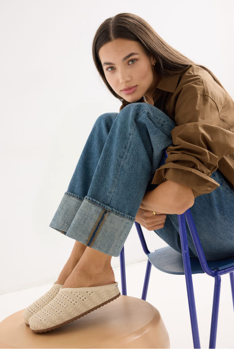 Woman sitting on a chair wearing The Casual Clog in Powder Crochet.