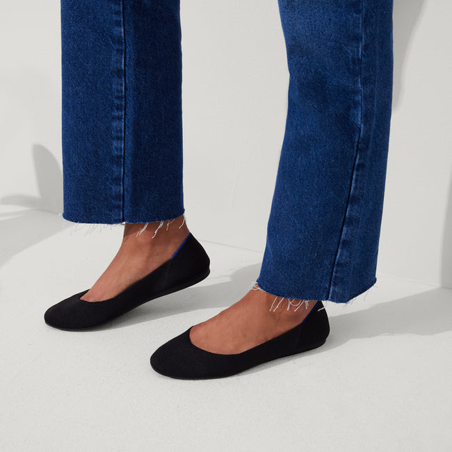 hover | The Square toe flat shoe in Black shown on-model at an angle.