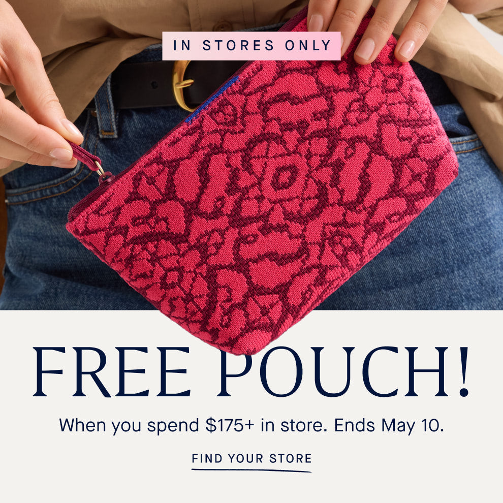 Image of a model holding The Petite Pouch in Cruiser Bloom, with copy overlay reading IN STORES ONLY | FREE POUCH! When you spend 175+ in store. Ends May 10. | FIND YOUR STORE