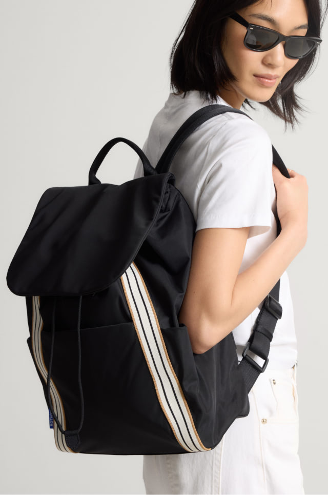 Model Carrying The Travel Backpack in Ink.