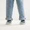A child modeling The Kids Strap Sneaker in Berry Blue. 