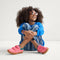 A child modeling The Kids Strap Sneaker in Watermelon. 