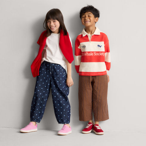 Two kids wearing The Kids Stretch Sneaker	in Firecracker and Bubblegum.