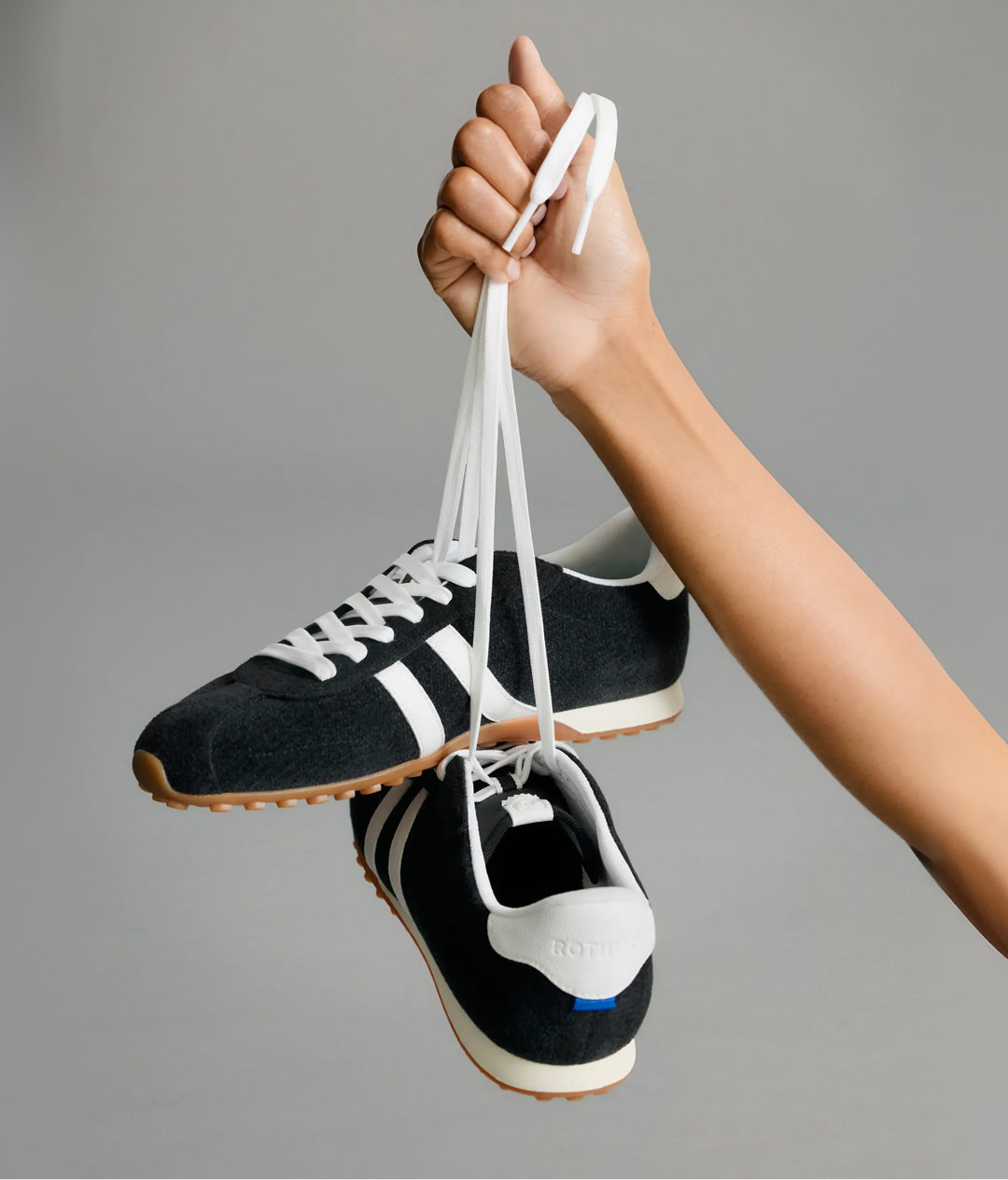 Hands holding The Ivy Sneaker	in ReVelvet Black.