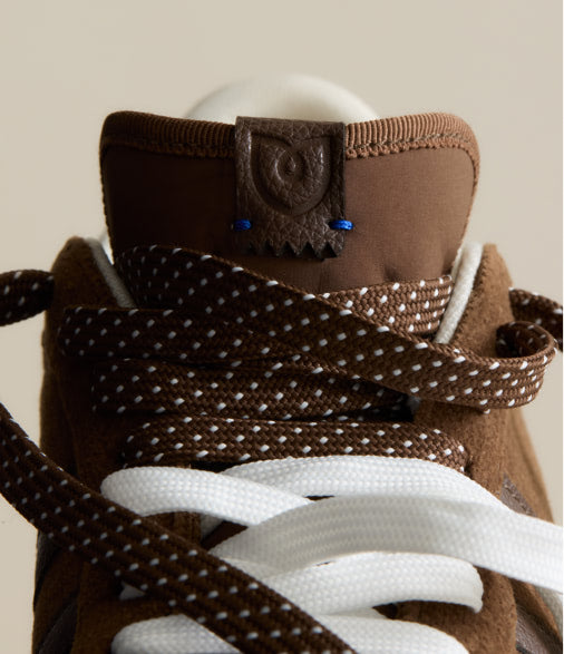 Close-up shot of The Ivy Sneaker	in ReVelvet Syrah focusing on the laces.