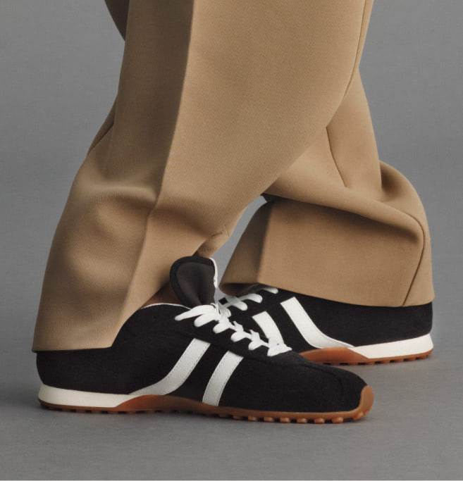 Model wearing The Ivy Sneaker	in ReVelvet Black.
