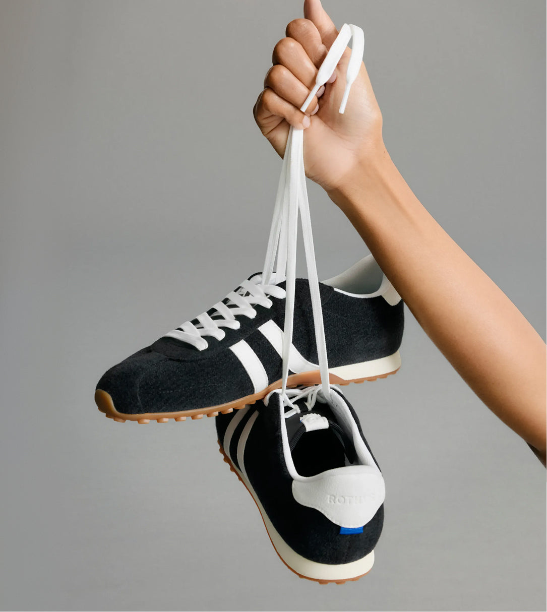 Hands holding The Ivy Sneaker	in ReVelvet Black.