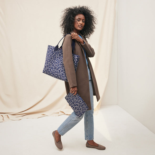 An alternate view of model holding The Lightweight Tote in Indigo Cat.