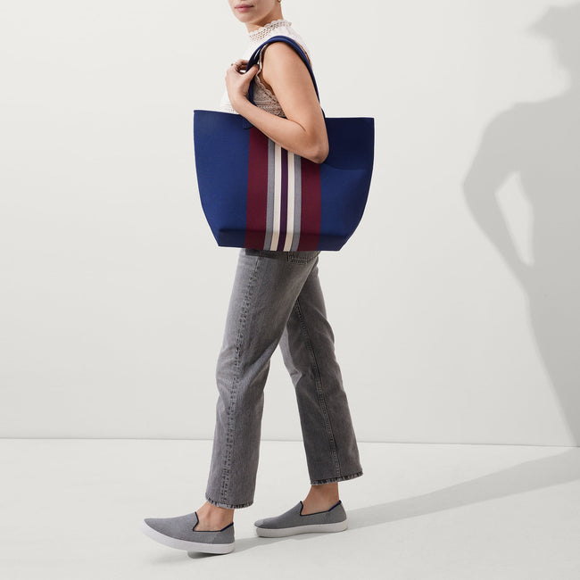 An alternate view of model holding The Lightweight Tote in Oxford Heel Stripe.