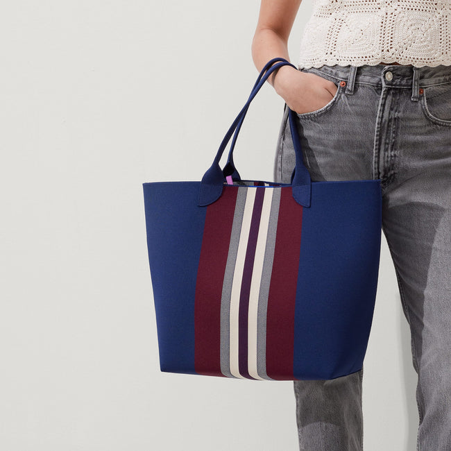 hover | Model holding The Lightweight Tote in Oxford Heel Stripe.