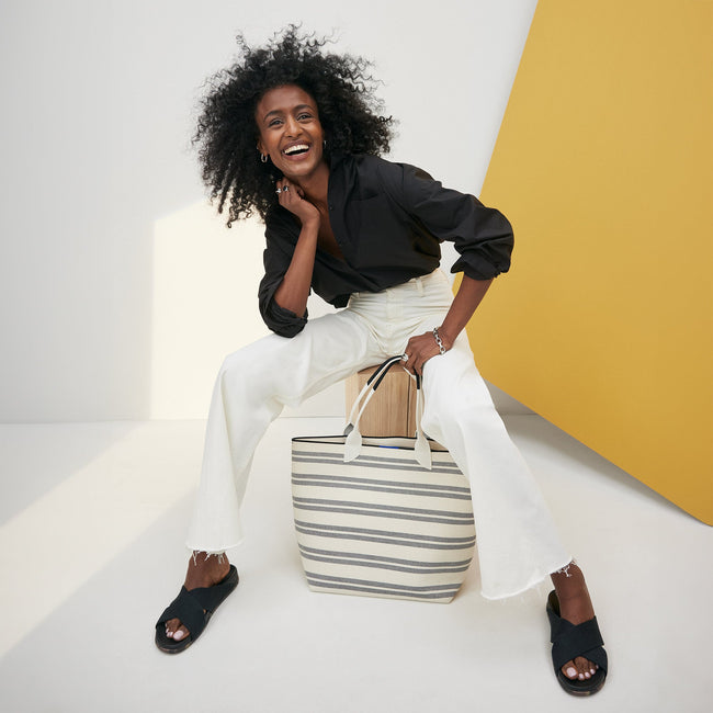 A model holding The Lightweight Tote in Polar Stripe.