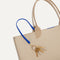 Close up of the handles and key leash detail of The Lightweight Tote in Soft Sesame. 
