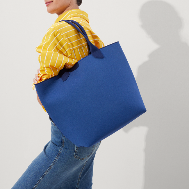 Model holding The Lightweight Tote in Varsity Blue.