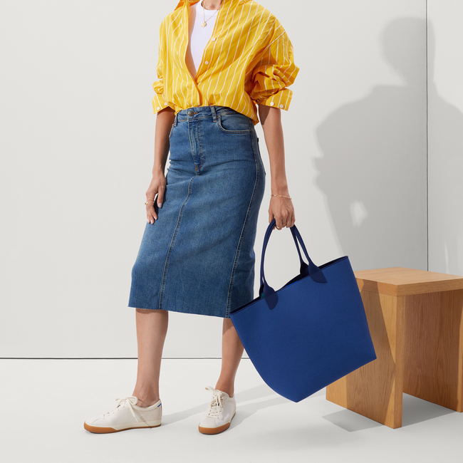 An alternate view of model holding The Lightweight Tote in Varsity Blue.