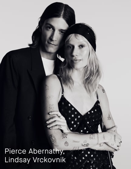 Black and white portrait of a man and woman standing together against a plain light background, with the text 'Pierce Abernathy, Lindsay Vrckovnik' in the lower left corner.