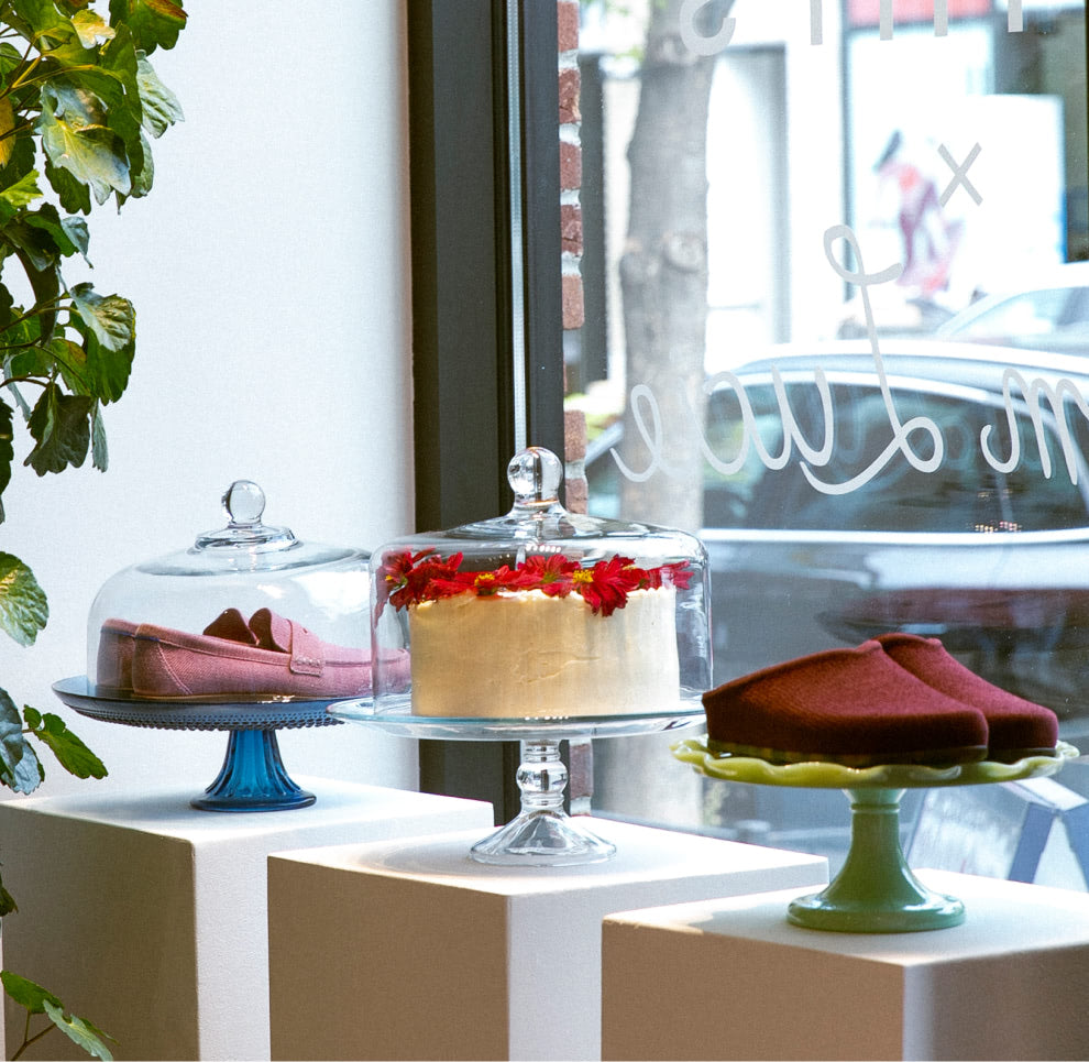 Decorative cakes on stands with a window view in the background