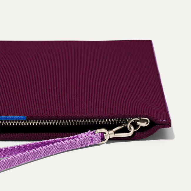 Close up of the zipper closure and wrist strap of The Wristlet in Collegiate Currant.
