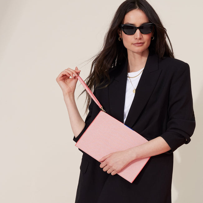 Model holding The Wristlet in Coral Grid.