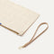A closeup of The Wristlet in Ivory Perf, focusing on the wrist strap.