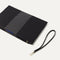 The Wristlet in Shadow Black shown with the wrist strap detached. 