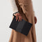 hover | Model holding The Wristlet in Shadow Black. 