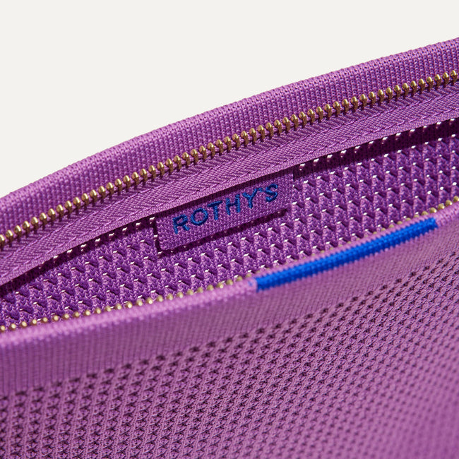 Close up of the zipper closure and wrist strap of The Wristlet in Summer Berry.