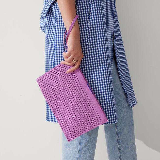 Model holding The Wristlet in Summer Berry. 