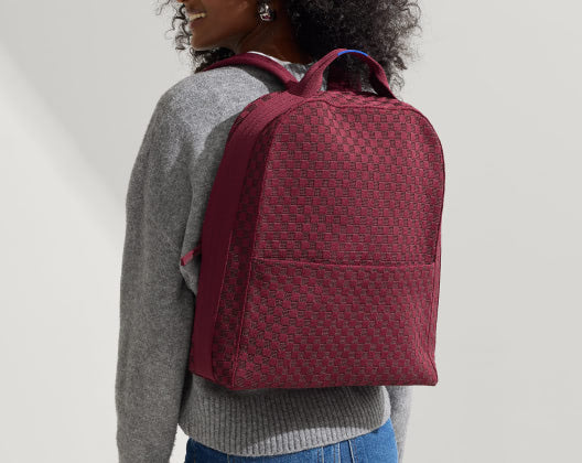 A stylish burgundy backpack made from recycled bottles in the colorway Grenache, perfect for everyday use and outdoor adventures.