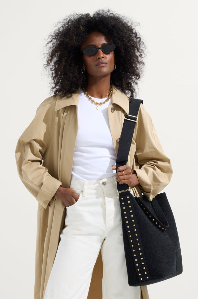 Model holding The ReVelvet™ Bucket Bag	in ReVelvet™ Black.