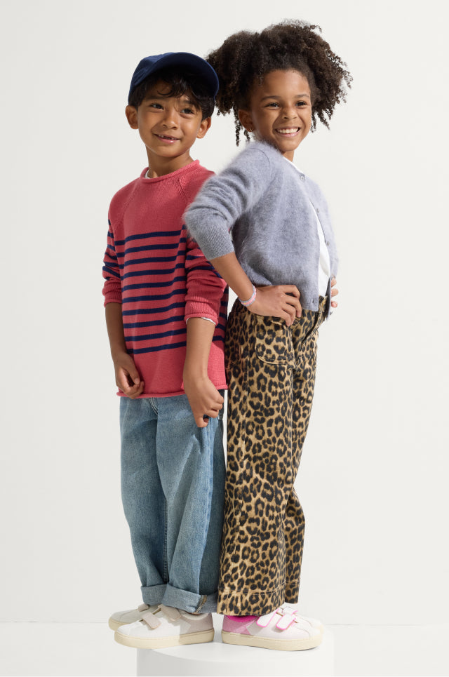 Two children standing side by side, wearing The Kids Strap Sneaker in Pink Taffy and Vanilla Ice.
