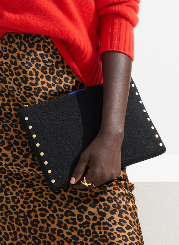 Model holding The Convertible Clutch in Studded Black.