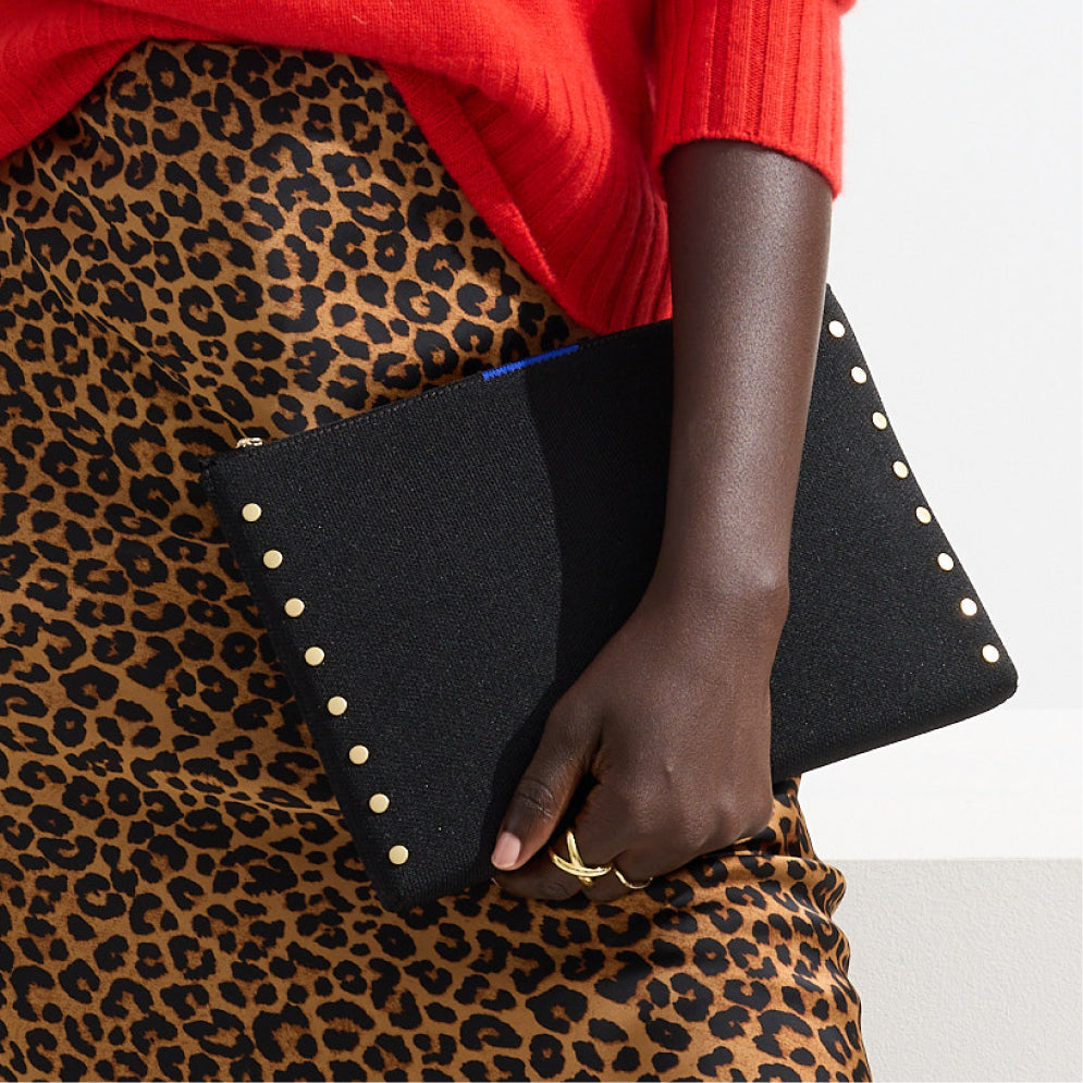 Model holding The Convertible Clutch in Studded Black.