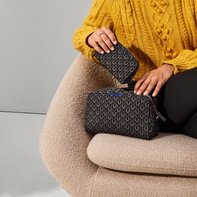 The Universal Pouch in Signature Black held by model.