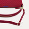 A closeup of The Daily Crossbody Bag in Cranberry, showing the smooth zipper closure and soft, flexible handle.