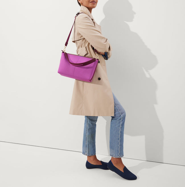 The Daily Crossbody in Soft Orchid, carried over the shoulder of a female model, shown from the right.