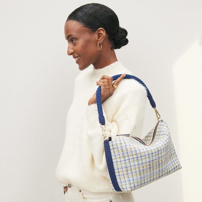 The Daily Crossbody in Spring Tweed, carried by its top handle by a model.