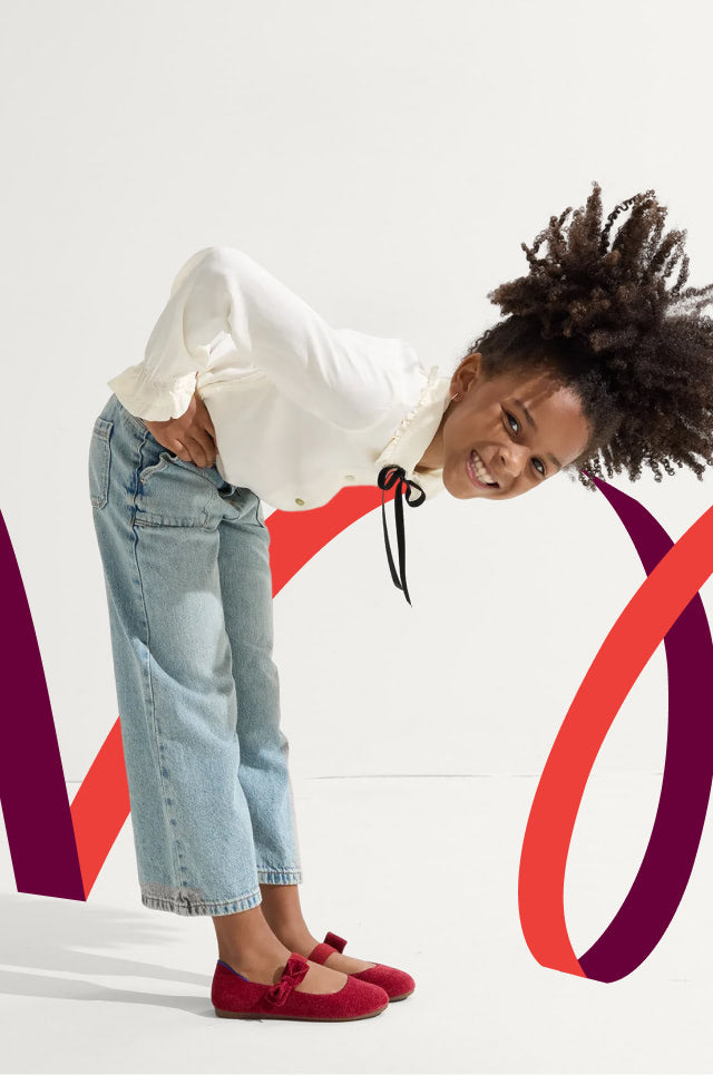 Young girl in a white shirt, blue jeans, and The revelvet Bow Mary jane.