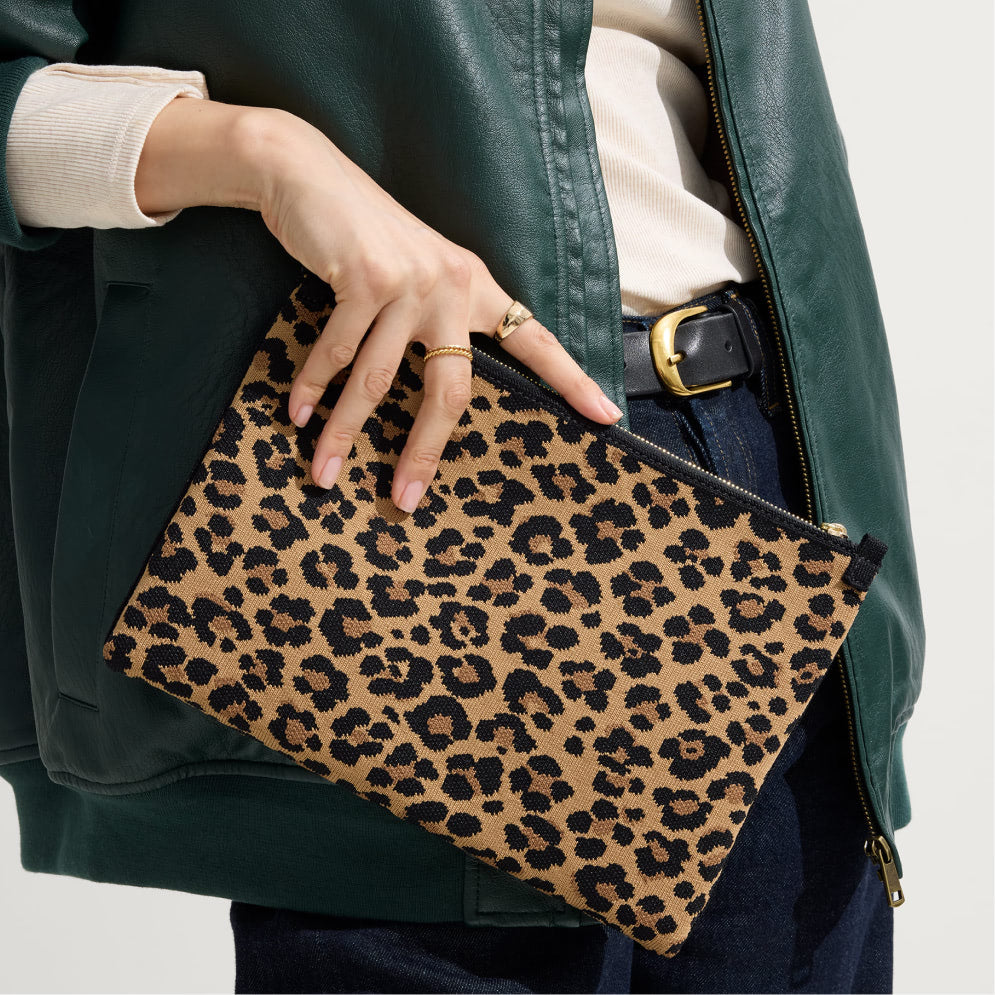 Person holding The Convertible Clutch in Toasty Cat with a green jacket and white shirt.