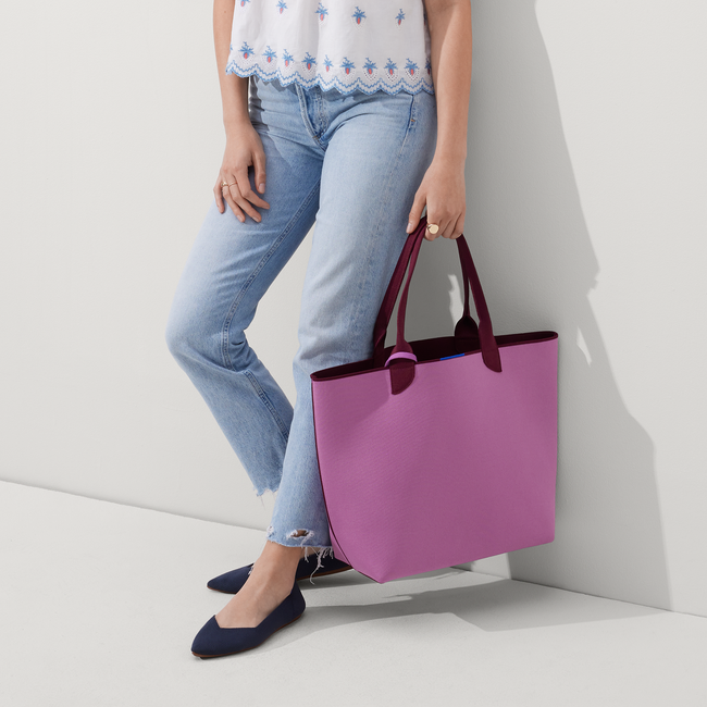 An alternate view of model holding The Reversible Lightweight Tote in Collegiate Currant.