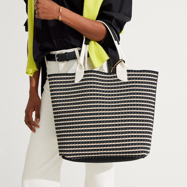 Model holding The Lightweight Tote in Black & White Checkers.
