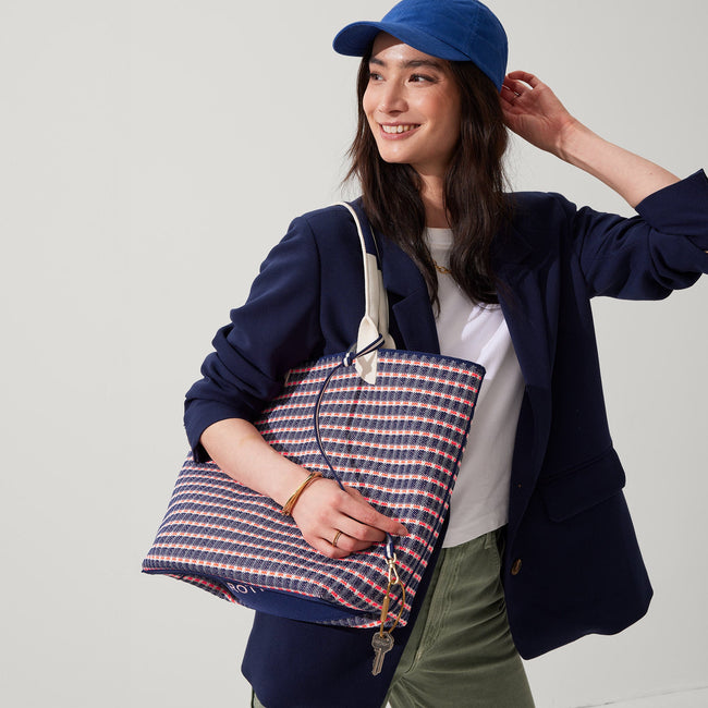 Model holding The Lightweight Tote in Navy & Pink Checkers.