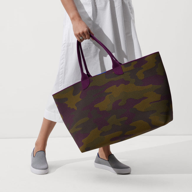 The Lightweight Mega Tote in Legacy Camo, carried by its top handles by a model, shown from the front. 