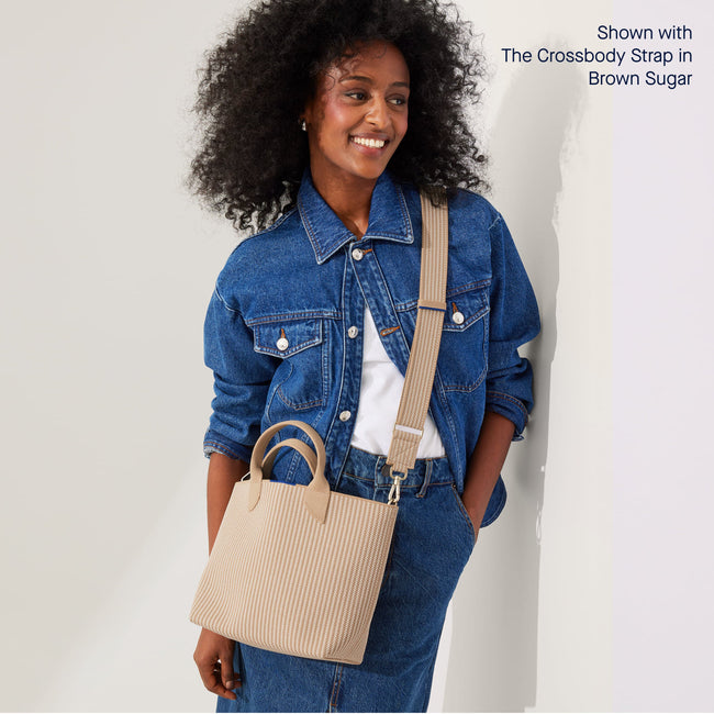 The Lightweight Petite Tote in brown Sugar, worn as a crossbody by a model, shown from the side with the Crossbody Strap in Brown Sugar.