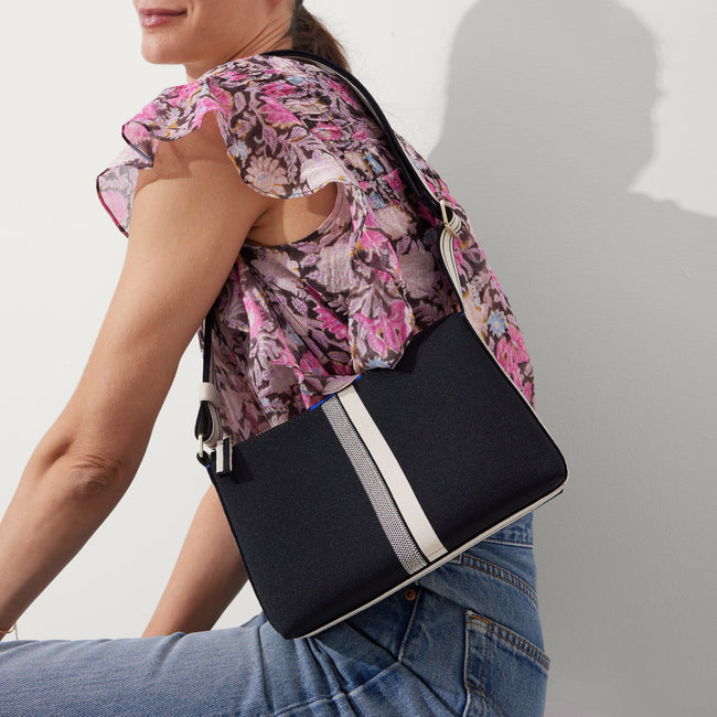 The Casual Crossbody in Black & Ivory Stripe, worn over the shoulder by a model, shown from the side. 